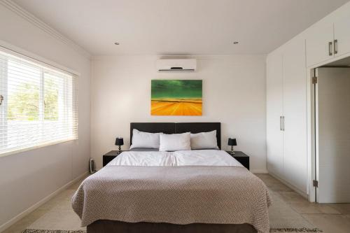 德班Casa Casa - Studio的卧室配有一张床,墙上挂有绘画作品