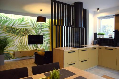 科沙林W&K Apartments - Gold Suite的厨房以及带桌子和电视的用餐室。