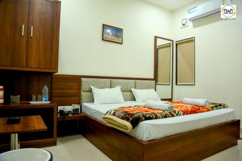 马图拉HOTEL BABYLON REGENCY, Opp Krishna Janmabhoomi Temple的一间卧室配有一张带木制床头板的床