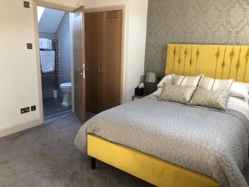 盖登Christmas Hill Farm的一间卧室配有一张带黄色床头板的大床