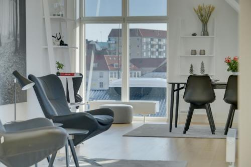 森讷堡Harbour Penthouse的配有椅子和桌子的房间以及窗户