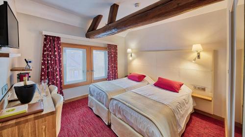 梅斯尼圣佩尔Logis Maison Gublin - Auberge du Lac的酒店客房设有两张床和电视。