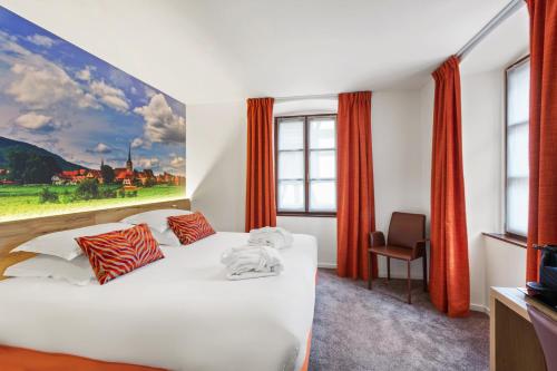 凯泽贝尔Hotel KLE, BW Signature Collection的卧室配有一张白色床,墙上挂有绘画作品