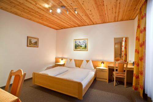 特翁特维格霍夫酒店的酒店客房带一张床铺、一张书桌和一间卧室