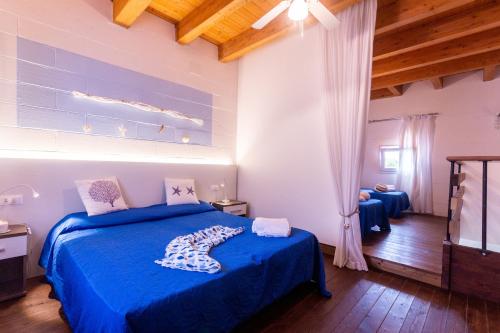 杜纳维德都娜罗萨住宅酒店的一间卧室配有蓝色的床、蓝色的床单和木制天花板