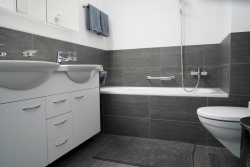 SagognWohnen wie Zuhause的一间带水槽、浴缸和卫生间的浴室
