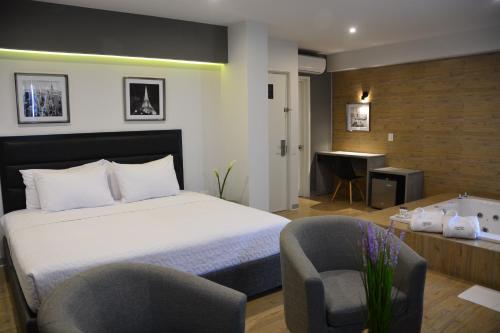 特鲁希略Awqa Concept Hotel的一间卧室配有一张床、两把椅子和一张书桌