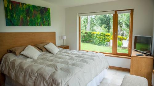 圣卡洛斯-德巴里洛切Quinto Elemento Bariloche的一间卧室设有一张大床和一个窗户。