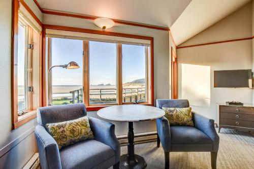 卡农海滩波浪酒店的一间设有两把椅子、一张桌子和一个窗户的房间