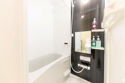 福冈TRIP POD TOJIN-MACHI A的带浴缸和盥洗盆的浴室