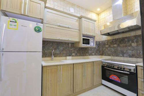 布赖代Al Saraya Chalet Families Only的厨房配有白色冰箱和微波炉