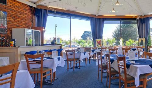莫韦尔Cedar Lodge Motel的用餐室设有桌椅和窗户。