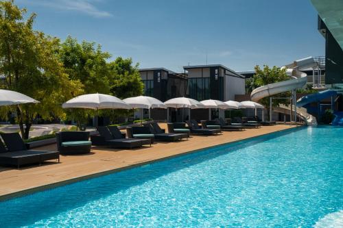亚兰旁特拉维罗酒店 的一个带躺椅和遮阳伞的游泳池