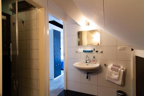 MaasbrachtGastenverblijf 't Smedenhuys的一间带水槽和镜子的浴室