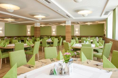 皮恩山口附近施皮塔尔Seminar- & Sporthotel Freunde der Natur的用餐室配有桌子和绿色椅子