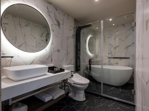高雄宫赏艺术大饭店的一间带水槽、浴缸和卫生间的浴室