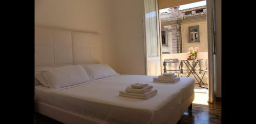 卡利亚里卡利亚里达玛雷维亚罗马酒店的窗户间里一张带毛巾的床