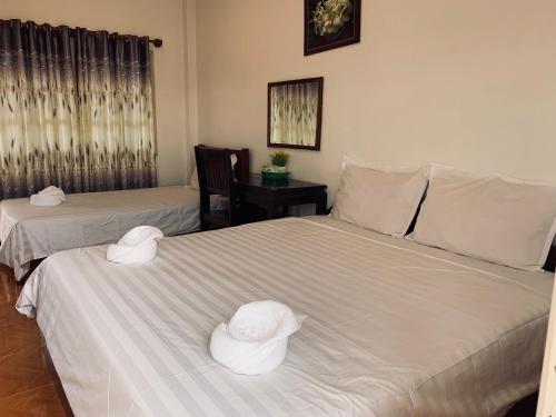 东德岛达洛姆旅馆的两张带帽子的床,位于一间房间里