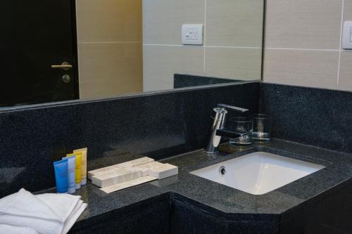 麦克坦Savoy Hotel Mactan的浴室的柜台设有水槽和镜子