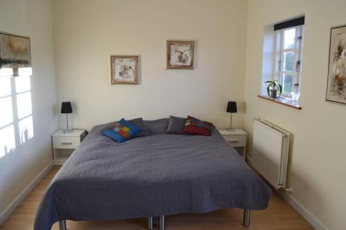 乌尔夫堡Mosborg的一间卧室配有一张带蓝色棉被的床