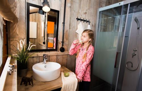 霍登哈根Serengeti Park Resort的站在浴室里刷牙的女人