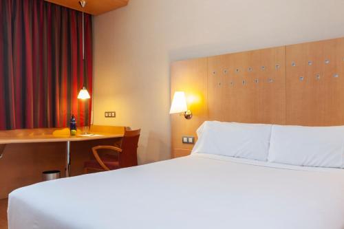 圣塞巴斯蒂安德洛斯雷耶斯Hotel SB Express Madrid Norte的配有一张床和一张书桌的酒店客房