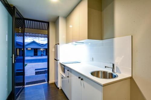芒特甘比尔Aloha Central Premium Studios的白色的厨房设有水槽和窗户