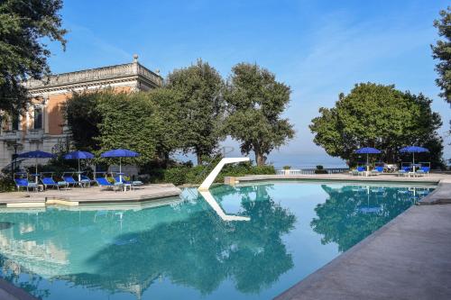 索伦托帕克德普林西比酒店的一个带蓝色椅子和遮阳伞的游泳池