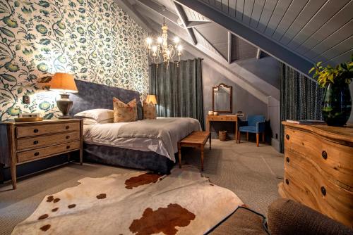 弗朗斯胡克Avondrood Guest House by The Oyster Collection的一间卧室配有一张床、梳妆台和书桌