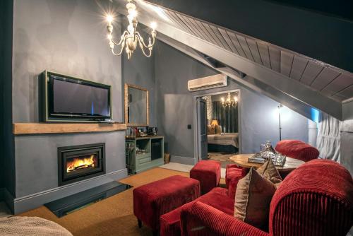 弗朗斯胡克Avondrood Guest House by The Oyster Collection的客厅设有壁炉和红色椅子