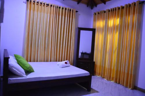康提Seven Luck Palace的一间卧室配有一张带黄色窗帘和镜子的床