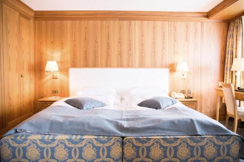 阿罗萨阿罗萨库尔姆阿尔平Spa酒店的一间卧室配有一张大床和两个枕头