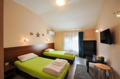 普罗夫迪夫Best Rest Guest Rooms的酒店客房设有两张床和一张桌子。