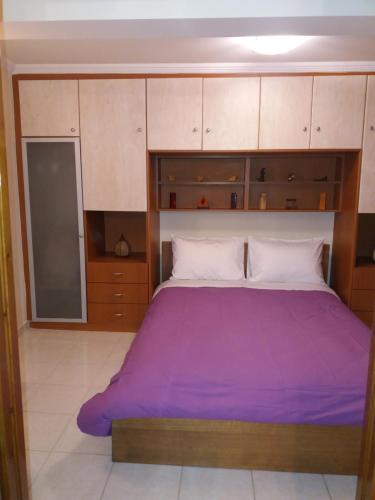 马尔马里Marmari vacation flat的一间卧室配有一张带紫色床单的大床