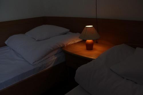 普热梅希尔欧洲酒店的一间卧室设有两张床和一张桌子上的台灯。