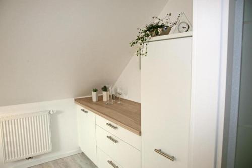 维尔德斯豪森Zuhause Woanders - Kuhtrade的厨房配有白色橱柜和木台面