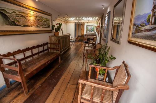 欧鲁普雷图奥普拉太阳酒店的客厅铺有木地板,配有木制长凳
