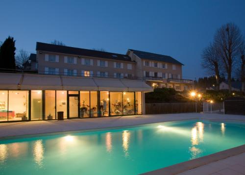 利尼翁河畔勒尚邦贝尔霍里赞酒店的一座游泳池,在晚上在建筑物前