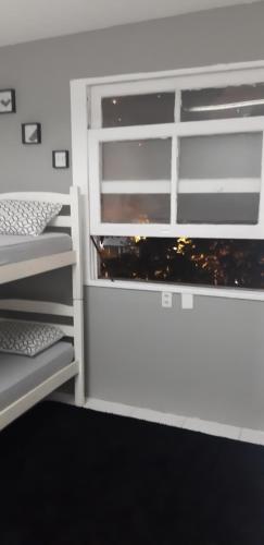 里约热内卢Quarto com suíte para mulheres的客房设有两张双层床和一扇窗户。
