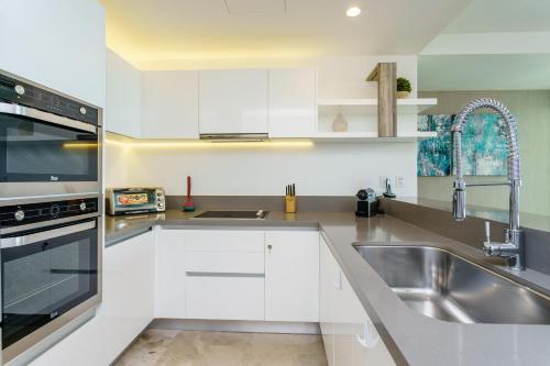 普拉亚卡门Oceana by ABNA的厨房配有白色橱柜和不锈钢盥洗盆