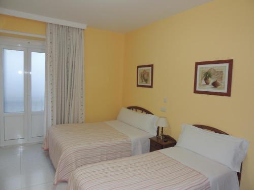 马德里冈萨洛旅馆的酒店客房设有两张床和窗户。