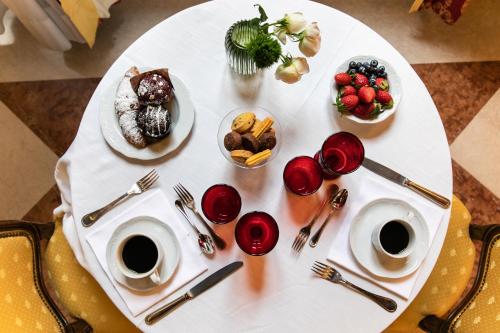 威尼斯Ca' Vendramin Zago的一张带食物盘和咖啡杯的白色桌子