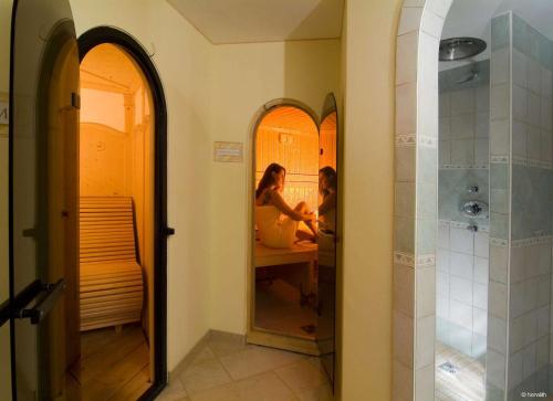 布利克森塔勒Alpenhof Brixen的浴室内镜子中的两人反射