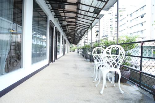 曼谷波仕套房酒店的阳台上一排白色椅子