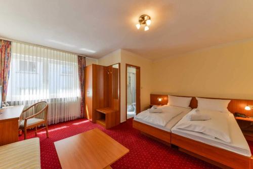Kirchhain黑森州霍夫酒店的酒店客房设有一张大床和一张书桌。