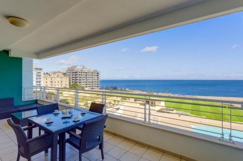 斯利马斯利马海滨公寓的阳台配有桌椅,享有海景。