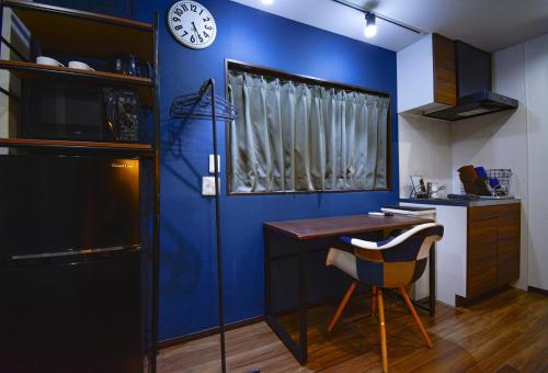 东京043AKIHABARA的厨房设有蓝色的墙壁、桌子和时钟