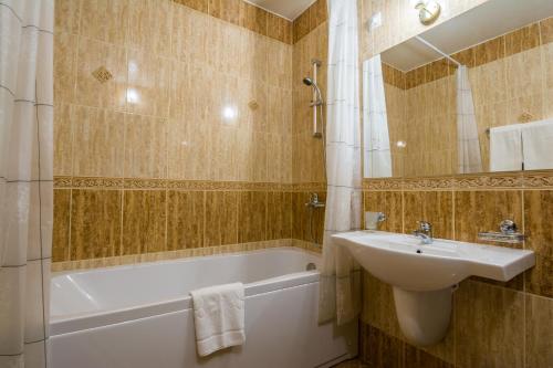 索非亚Aris Hotel Sofia的浴室配有盥洗盆、浴缸和盥洗盆