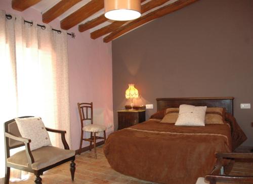 巴涅雷斯德马里奥拉运河之眼旅舍的卧室配有床、椅子和窗户。