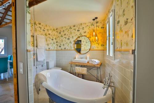 孔苏埃格拉El Patio de los Jazmines Boutique-House的浴室设有浴缸,装饰有黄色壁纸